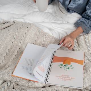 Person reading a spiral-bound book on a textured surface
