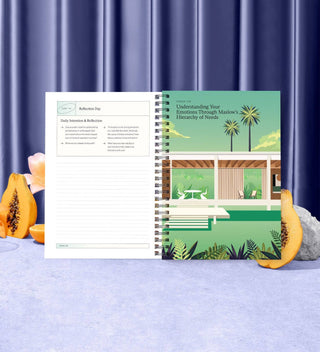 Notebook with a scenic cover on a blue surface with decorative items