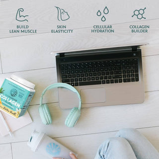 Laptop with a container of collagen powder, headphones, and a phone on a light wooden surface.