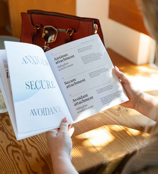 Person holding open a book with psychological concepts on a wooden surface