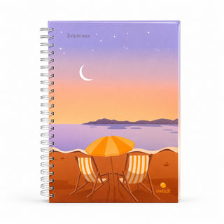 A spiral-bound notebook with a beach sunset cover design. The cover illustration shows a purple and orange sky with stars and a crescent moon over water, with two striped beach chairs and an orange umbrella on the sand.